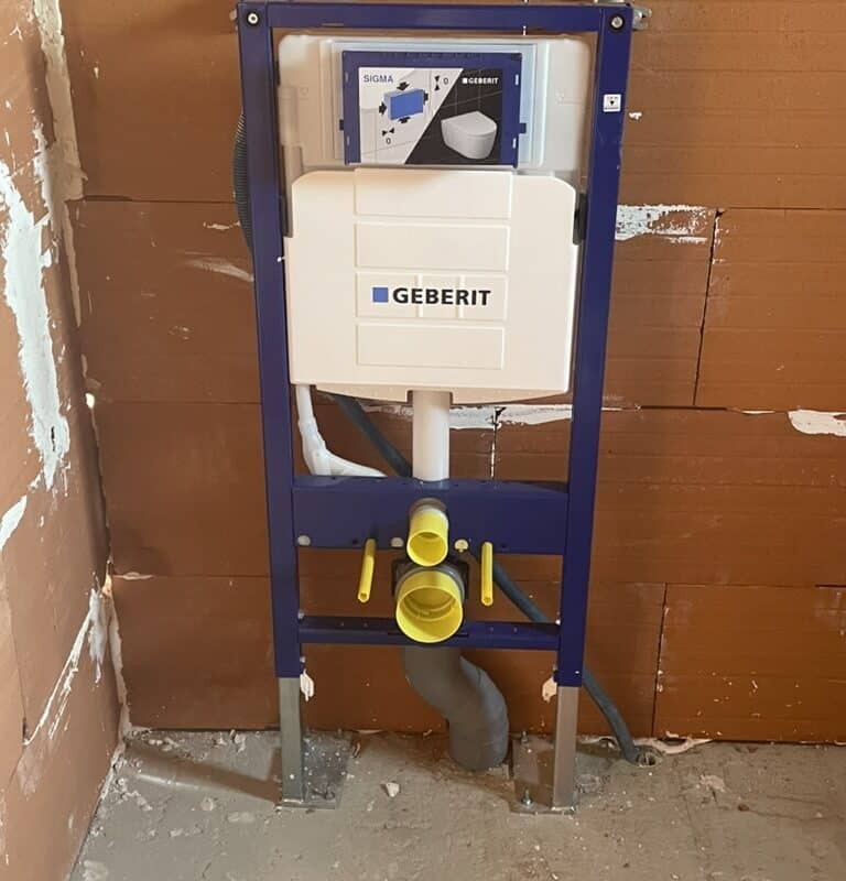 Installation réservoir WC encastré Geberit sur mur brique.